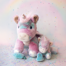 Load image into Gallery viewer, Two plush unicorn toys on a colorful background with a rainbow.