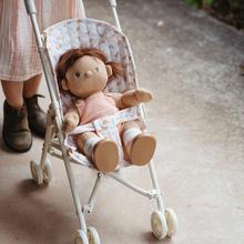 Load image into Gallery viewer, Doll in a small stroller with a child's feet visible in the background
