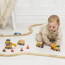 Load image into Gallery viewer, Child playing with toy cars and tracks on a white floor.