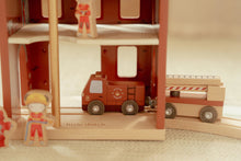 Load image into Gallery viewer, Wooden toy fire station with a red fire truck and figures on a neutral background