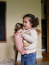 Load image into Gallery viewer, Child holding a doll in a pink carrier with a neutral background