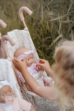 Load image into Gallery viewer, Child holding a baby doll in a stroller with a blurred natural background