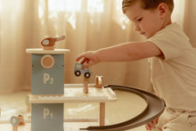 Load image into Gallery viewer, Child playing with wooden toys on a table in a softly lit room