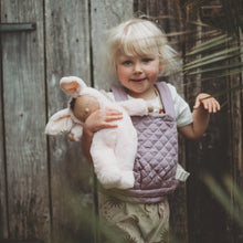 Load image into Gallery viewer, Child holding a plush toy in front of a lavender baby carrier
