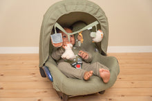 Load image into Gallery viewer, Baby in a green car seat on a wooden floor with a beige wall background and baby seat with Little Farm stroller chain
