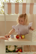 Load image into Gallery viewer, Child playing with toy fruits and vegetables on a wooden table with a striped canopy with a cash register
