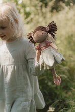 Load image into Gallery viewer, Child holding a doll with a blurred natural background
