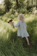 Load image into Gallery viewer, Child in a light dress walking through a grassy forest with Little Dutch Fairy Garden Evi toy fairy 
