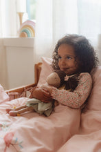 Load image into Gallery viewer, Child holding a doll in a cozy bedroom with soft lighting
