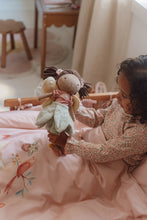 Load image into Gallery viewer, Child holding a plush toy Little Dutch Fairy Garden Evi toy fairy in a bed with pink bedding

