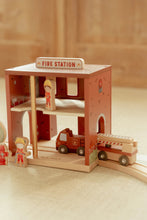Load image into Gallery viewer, Wooden toy fire station with a fire truck and figures on a wooden floor.
