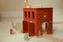 Load image into Gallery viewer, Wooden toy fire station with small figures on a neutral background
