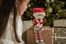 Load image into Gallery viewer, Child holding Christmas Little dutch Jim doll in front of a Christmas tree with presents.
