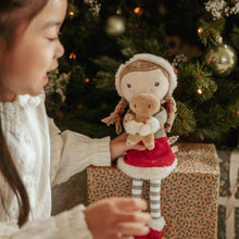 Load image into Gallery viewer, Child holding a plush toy little dutch Rosa with a Christmas gingerbread man
