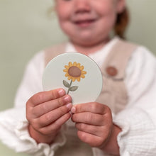 Load image into Gallery viewer, Child holding a round card with a sunflower design against a plain background
