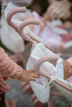Load image into Gallery viewer, Close-up of a child&#39;s hand reaching towards a pink baby stroller with a blurred background
