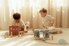 Load image into Gallery viewer, Two children playing with wooden toys on a light-coloured floor.
