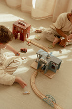 Load image into Gallery viewer, Two children playing with a wooden train set on a carpeted floor.
