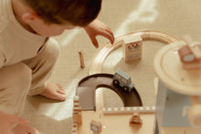 Load image into Gallery viewer, Child playing with a toy train set on a carpeted floor
