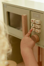 Load image into Gallery viewer, Child&#39;s hand pressing a button on a toy microwave oven.
