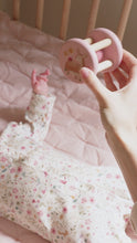 Load and play video in Gallery viewer, A baby playing with a pink and beige wooden roller rattle toy with a ball in the center and four cylindrical supports. With a pretty image of  deer and a ladybird.
