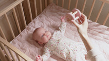 Load and play video in Gallery viewer, A baby playing with a pink and beige wooden roller rattle toy with a ball in the center and four cylindrical supports. With a pretty image of  deer and a ladybird. Little Dutch Fairy Garden Roller Rattle
