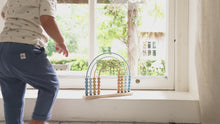 Load and play video in Gallery viewer, A rainbow-shaped abacus with beads in shades of blue and beige, constructed with a wooden base and metal frame.
